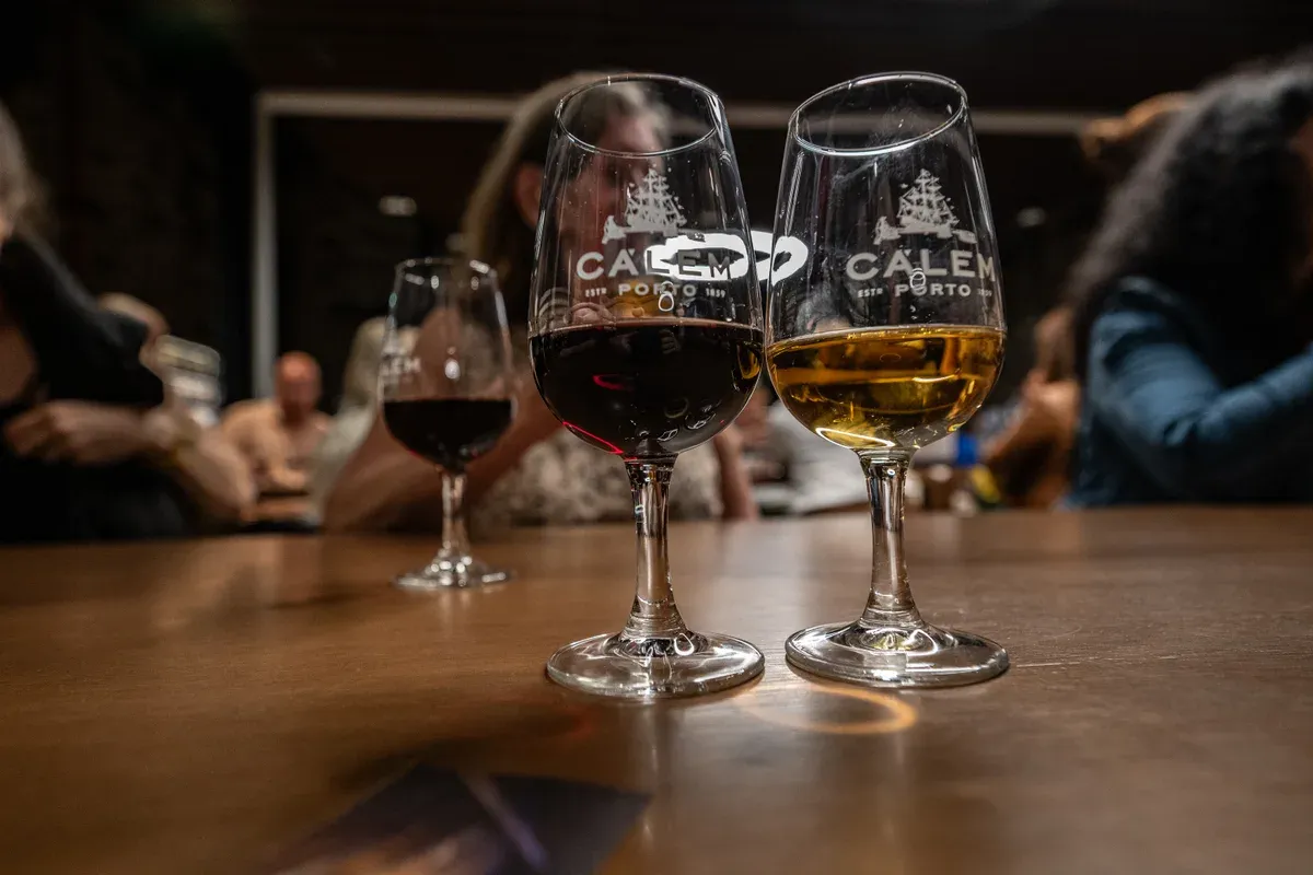 Glasses of ruby and tawny port on a table in the Cálem cellars, seen on a port wine cellar tour in Vila Nova de Gaia