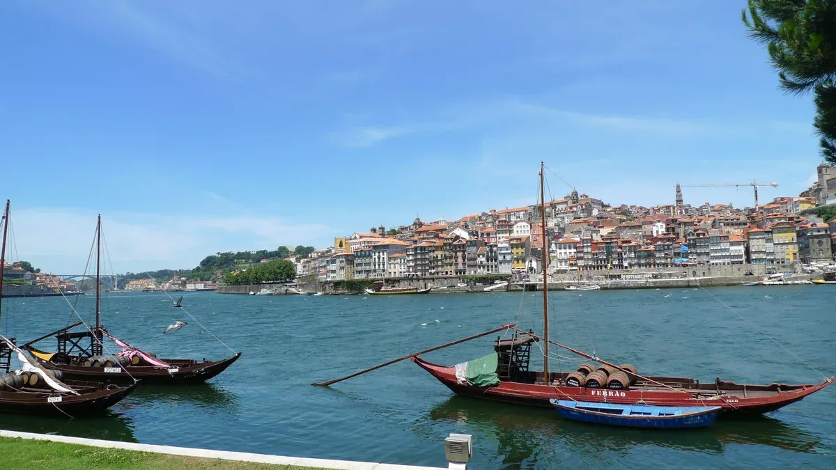 Rabelo boats on the Douro by the Gaia quay, with Porto across the river, seen on a port wine cellar tour in Vila Nova de Gaia