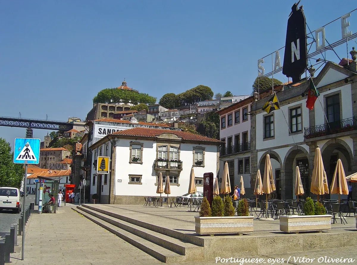 The Sandeman lodge and its cloaked figure on the square by the Gaia riverfront, seen on a port wine cellar tour in Vila Nova de Gaia